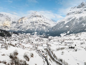 Eine verschneite Bergstadt mit einem Tal, Gebäuden und Straßen.