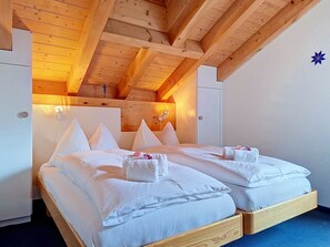 Ein Doppelzimmer mit Holzbalken, einem Bett mit weißer Bettwäsche und einem kleinen dekorativen Gegenstand an der Wand.