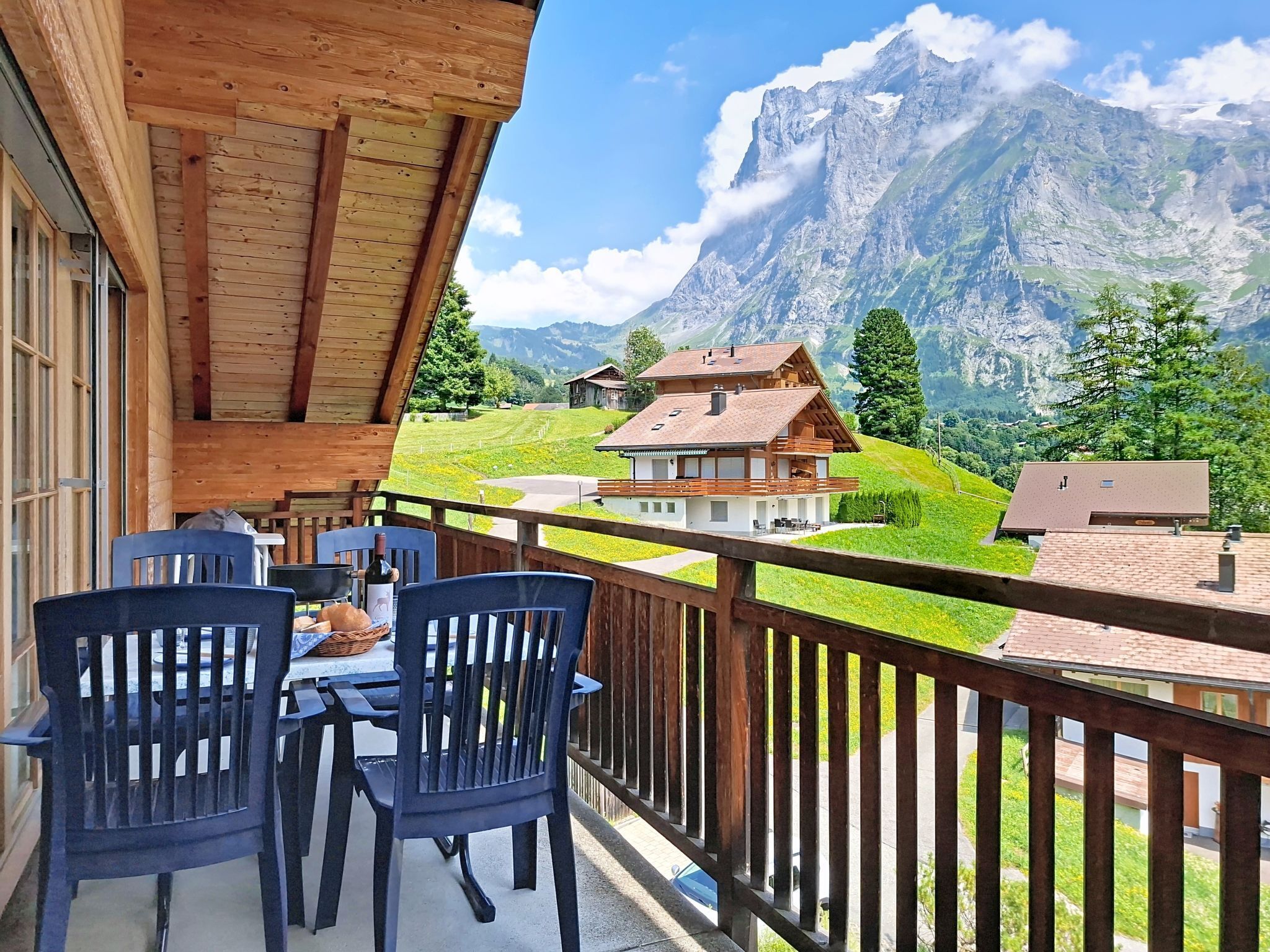 A balcony with wooden railings overlooking a mountainous landscape.