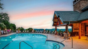 A swimming pool with lounge chairs and a stone building with a roof. - Eagle’s Roost - Views from the Top! (Banner Elk)