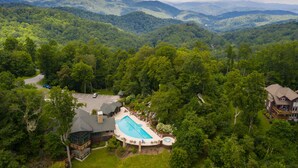 An aerial view of a resort with a swimming pool, guest cabins, and a mountain backdrop. - Eagle’s Roost - Views from the Top! (Banner Elk)