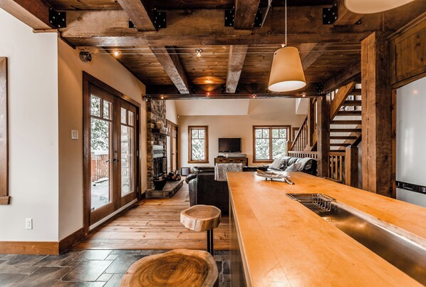 A spacious kitchen with a long wooden countertop, a built-in oven, and a large window.
