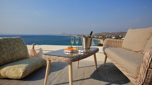 A wicker table with a plate of food, two glasses, and a bottle on a terrace overlooking the sea. - Villa Yellow.
Inviting you to discover it with every moment
Villa Paradise Hotel (Naxos)