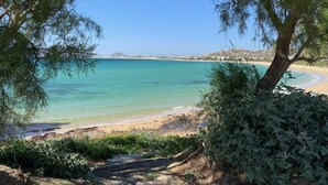 A beach with clear turquoise water, sandy shore, and a tree in the foreground. - Villa Yellow.
Inviting you to discover it with every moment
Villa Paradise Hotel (Naxos)