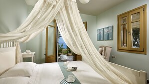 A bedroom with a canopy bed, a bedside table with a cup and a book, and a view of the outdoors through an open door. - Villa Yellow.
Inviting you to discover it with every moment
Villa Paradise Hotel (Naxos)
