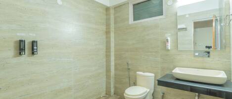 A modern bathroom with a toilet, bidet, and sink.