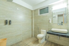 A modern bathroom with a toilet, bidet, and sink.