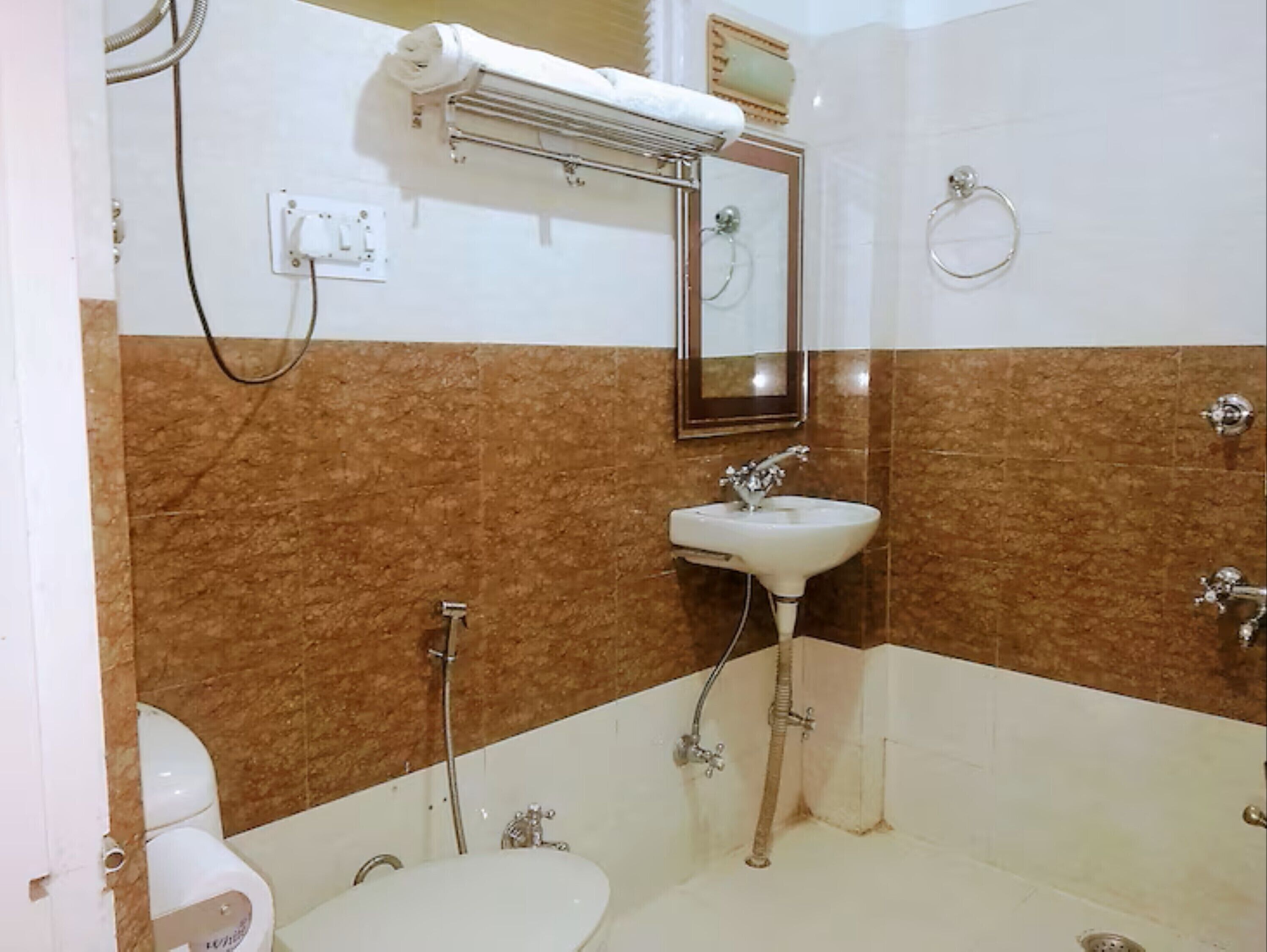 A bathroom with a white sink, a mirror, a towel rack, and a shower.