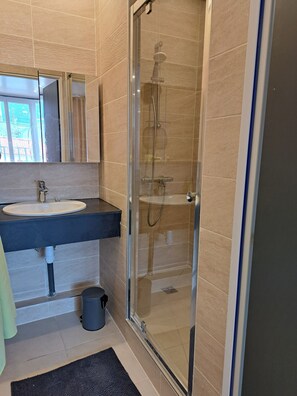 Een douche, een haardroger, handdoeken, toiletpapier