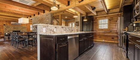 A spacious kitchen with dark wood cabinets, a granite countertop, and stainless steel appliances.