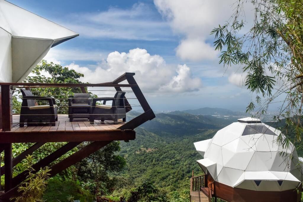 A wooden deck with outdoor furniture overlooking a mountainous landscape.