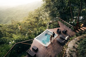 A wooden deck with a pool, surrounded by lush greenery and overlooking a forested valley. - Trekker Glamping (Santa Marta)