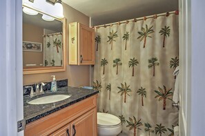 A bathroom with a sink, mirror, and toilet. - Beachfront St Petersburg Condo w/ Community Pool! (Treasure Island)