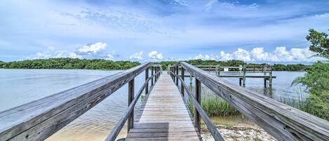 A wooden pier extending into a body of water with a clear sky above.