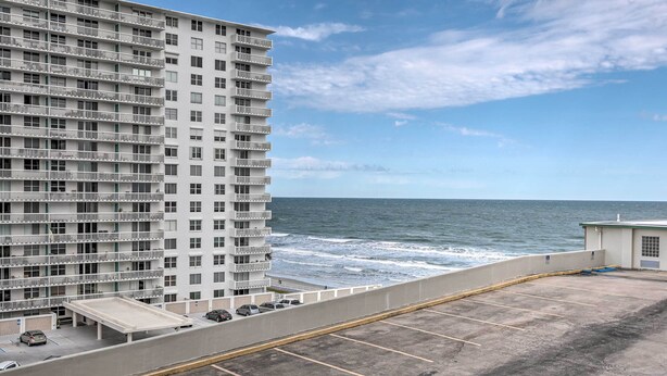 Un immeuble de grande hauteur doté de nombreux balcons donnant sur une plage.