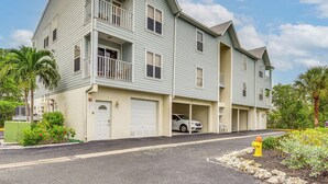 Un edificio residenziale a più piani con un garage, un balcone e un idrante.