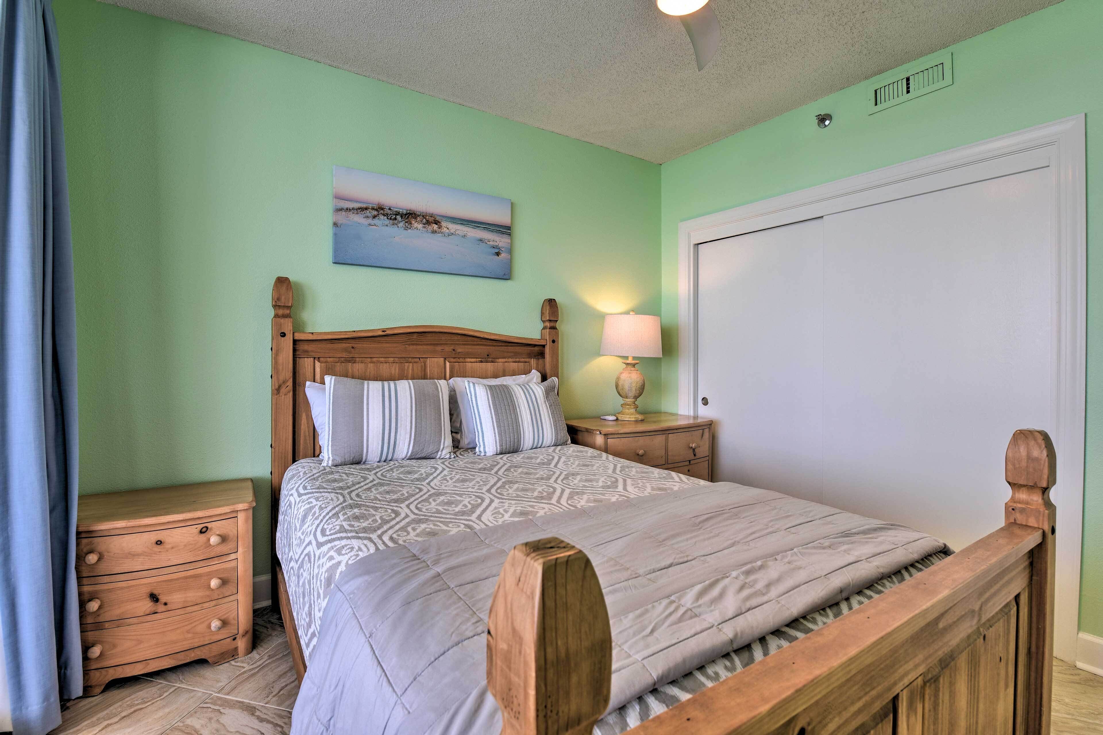 Un dormitorio con una cama de madera, una mesita de noche, una lámpara y un cuadro en la pared.