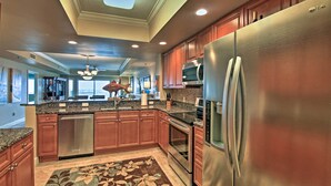 A spacious kitchen with wooden cabinets, stainless steel appliances, and a central island. - Beachfront Destin Condo w/ Pool & Harbor View! (Destin)