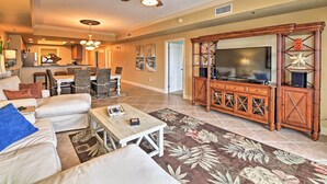A spacious living room with a large TV, comfortable seating, and a ceiling fan. - Beachfront Destin Condo w/ Pool & Harbor View! (Destin)