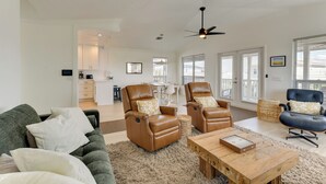 A spacious living room with leather armchairs, a sofa, and a wooden coffee table. - Steps to Ocean & Bay: Bradenton Beach Townhome! (Bradenton Beach)