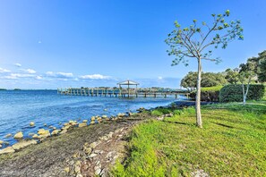 A coastal scene with a pier extending into the water, a gazebo, and a grassy area with a tree. - Steps to Ocean & Bay: Bradenton Beach Townhome! (Bradenton Beach)