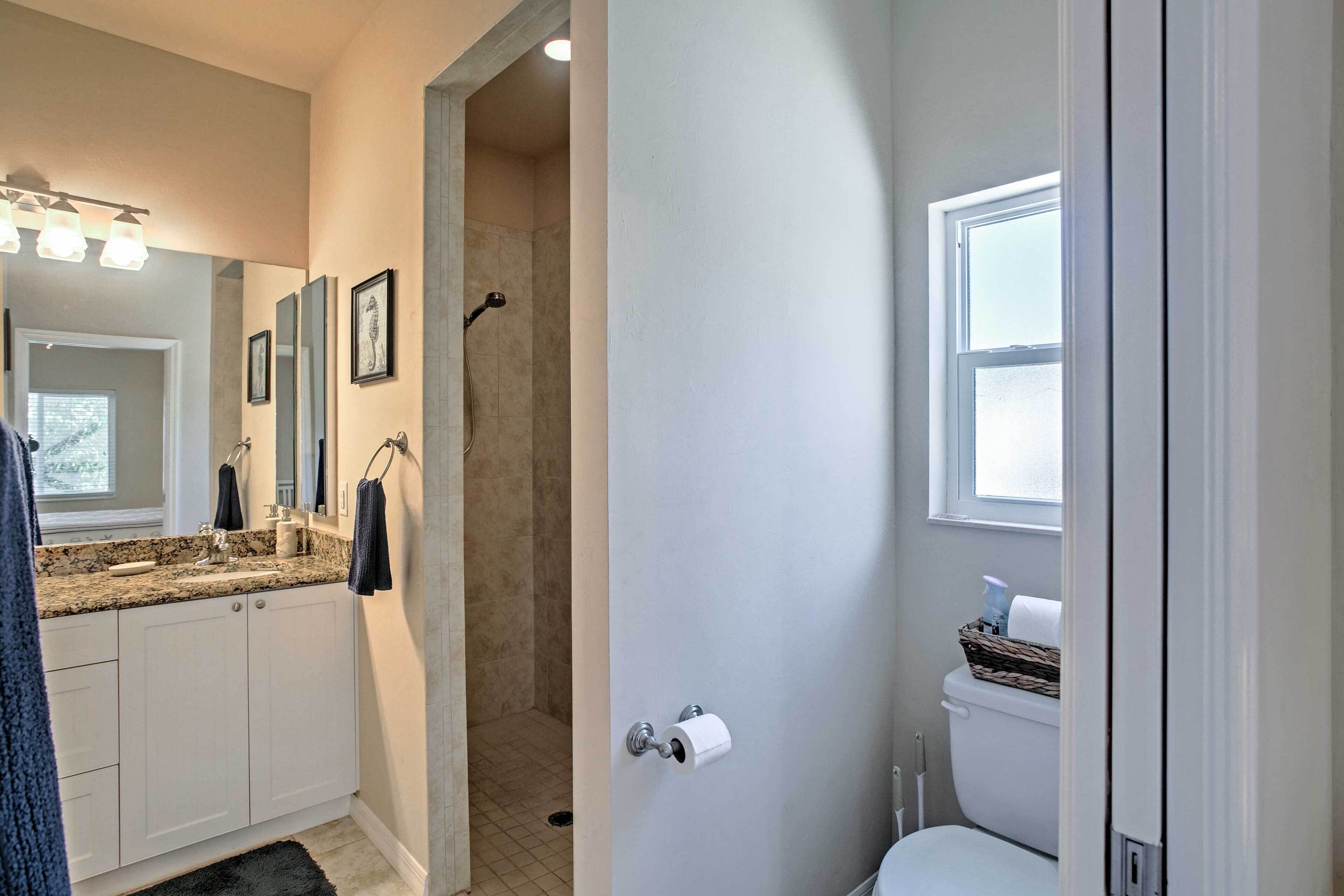A bathroom with a shower, toilet, and sink.