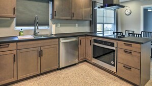 A modern kitchen with stainless steel appliances, wooden cabinets, and a built-in oven.