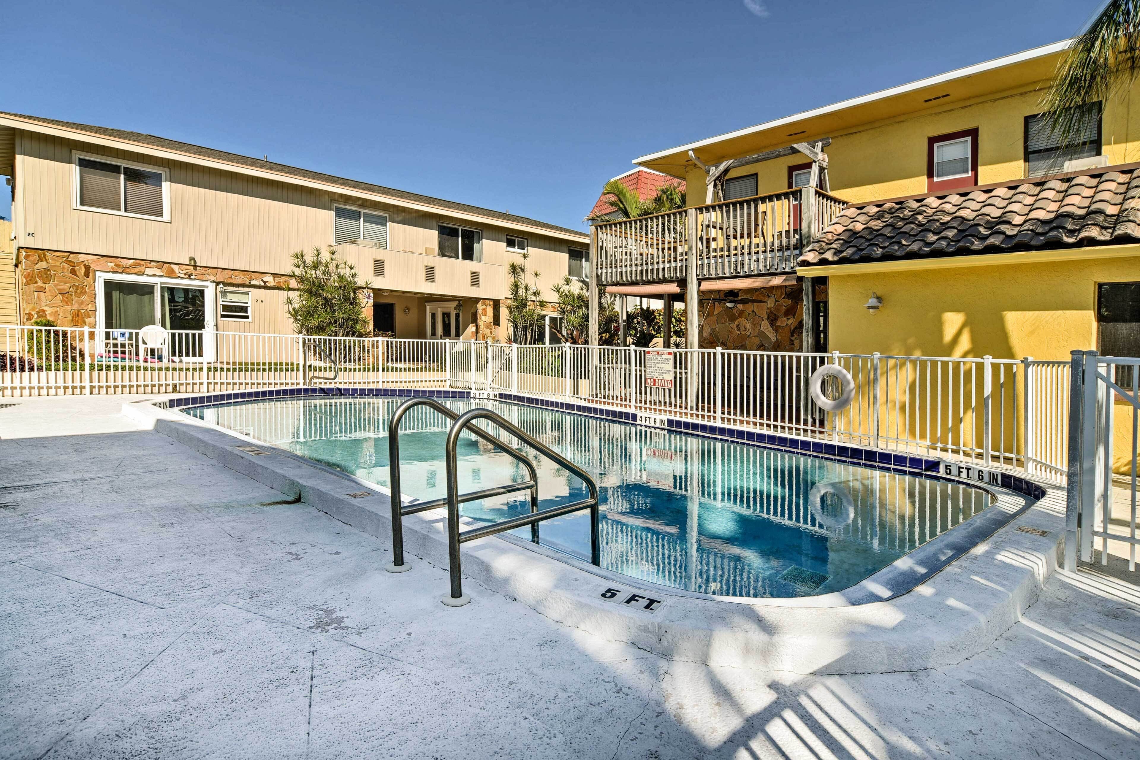 A swimming pool with a 6-foot depth marker, surrounded by a white fence.