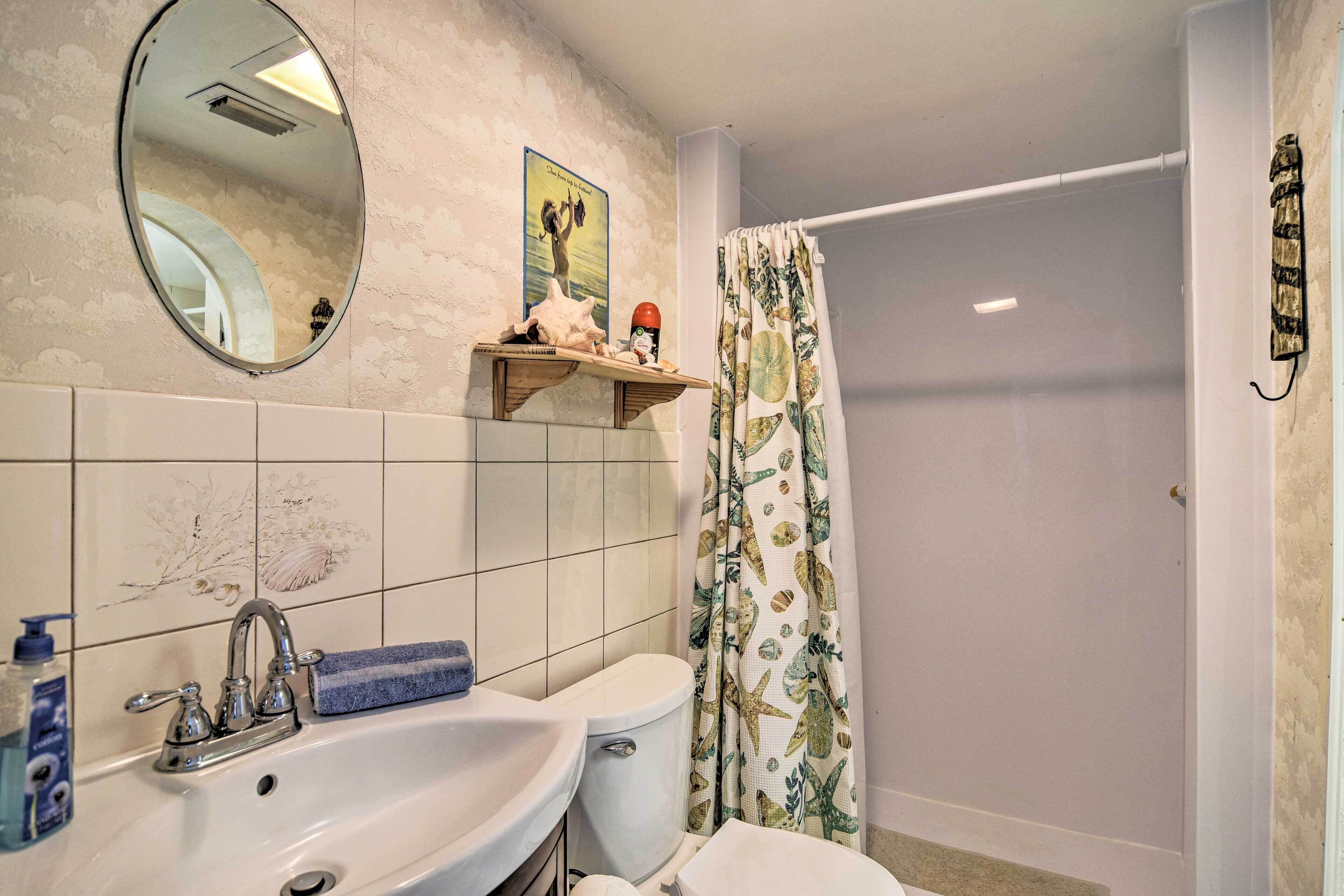 Un baño con lavamanos doble, inodoro y cortina de ducha.