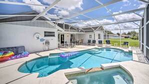 An outdoor swimming pool with a covered patio area, lounge chairs, and a view of the surrounding landscape. - Pool + Game Room, 5 Mi to Disney: Kissimmee Home! (Kissimmee)