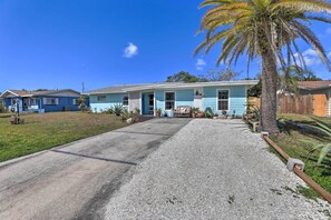 A single-story house with a front porch, a gravel driveway, and a palm tree. - Beachy Bradenton Vacation Home Near Ocean! (Bradenton)