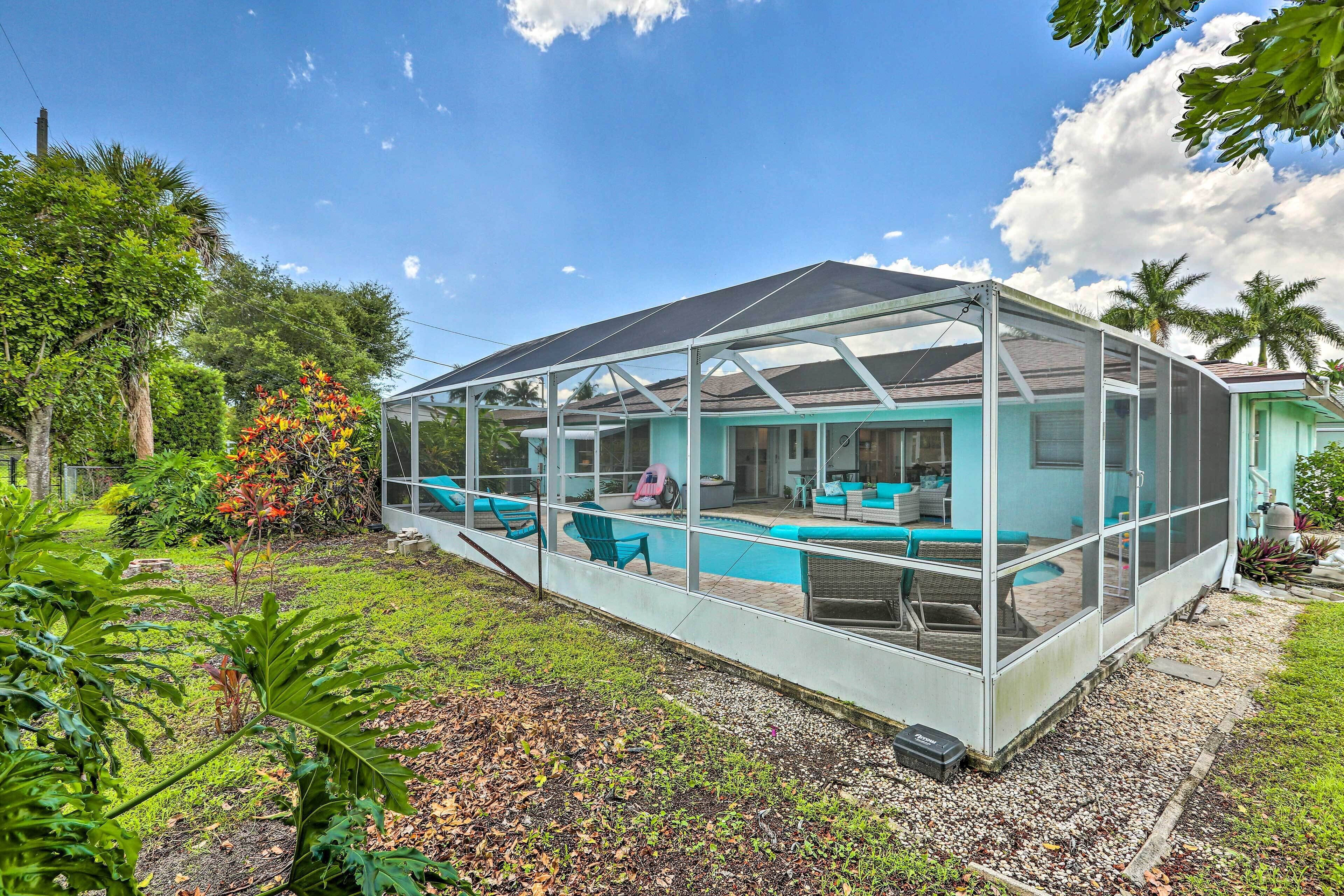 A covered outdoor area with a pool, seating, and a glass enclosure.