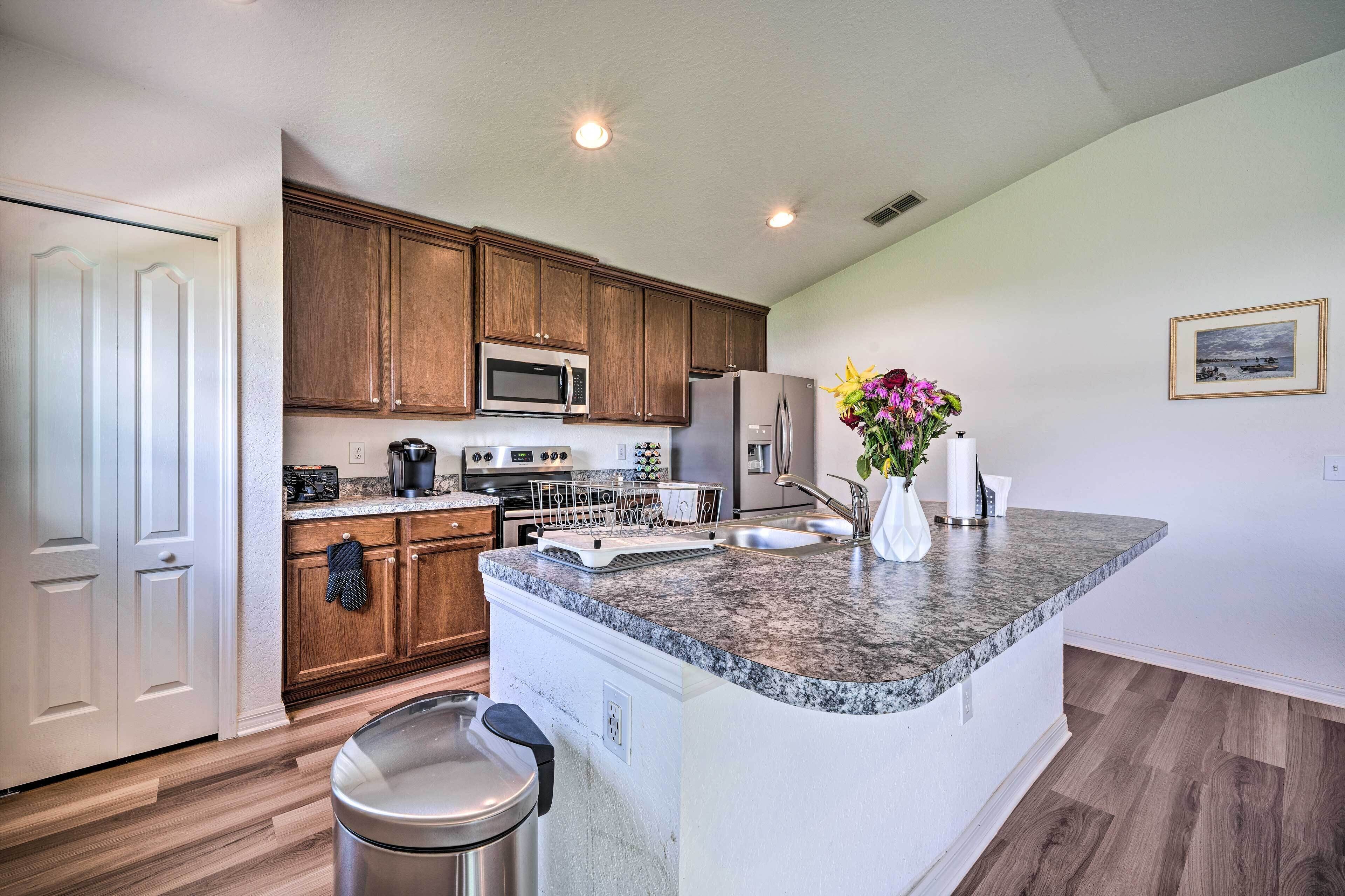 A modern kitchen with granite countertops, stainless steel appliances, and wooden cabinets.