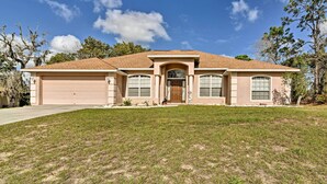 A single-story house with a garage, a front porch, and a well-maintained lawn. - Bright Spring Hill Home: 5 Mi to Weeki Wachee Park (Spring Hill)