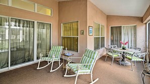 A sunlit patio with rocking chairs, a table, and chairs. - Bright Spring Hill Home: 5 Mi to Weeki Wachee Park (Spring Hill)