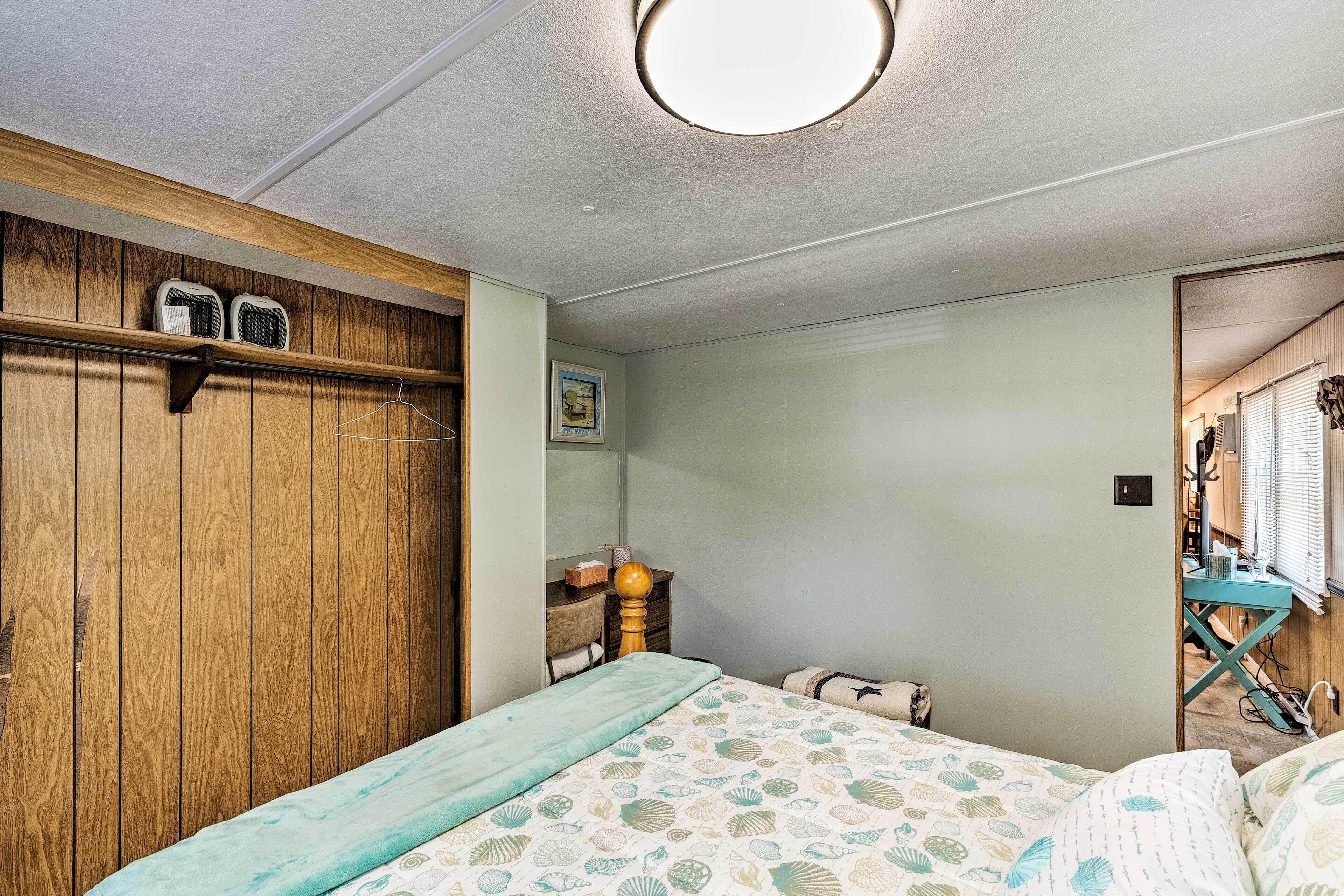 Une chambre à coucher avec un lit, une armoire en bois, un bureau et un miroir.
