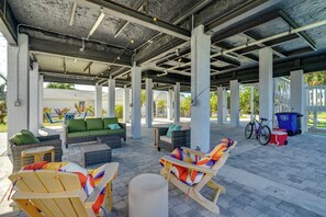 Eine überdachte Außenpatio-Terrasse mit Liegestühlen, einer Couch und einem Fahrrad.