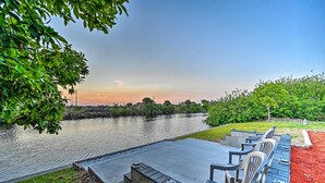 A riverside patio with outdoor seating and a view of the water. - Canal-front Cape Coral Home w/ Patio & Grill! (Cape Coral)
