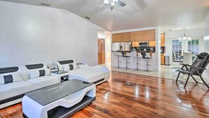 A spacious living room with a modern white sofa set, a glass coffee table, and a ceiling fan. - Canal-front Cape Coral Home w/ Patio & Grill! (Cape Coral)