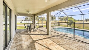 A covered outdoor area with a pool, patio furniture, and a ceiling fan. - Central Cape Coral House w/ Private Screened Pool! (Cape Coral)