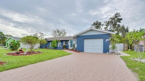 A residential house with a paved driveway, a garage, and a well-maintained lawn. - Convenient Sarasota Studio w/ Lush Backyard! (Sarasota)