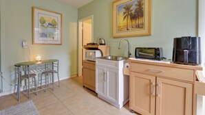 A compact kitchen with a dining area, a microwave, a toaster, and a coffee maker. - Convenient Sarasota Studio w/ Lush Backyard! (Sarasota)