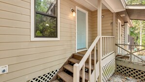 A wooden staircase leading to a door with a light fixture above it. - Charming Tallahassee Townhouse ~ 3 Mi to Fsu! (Tallahassee)