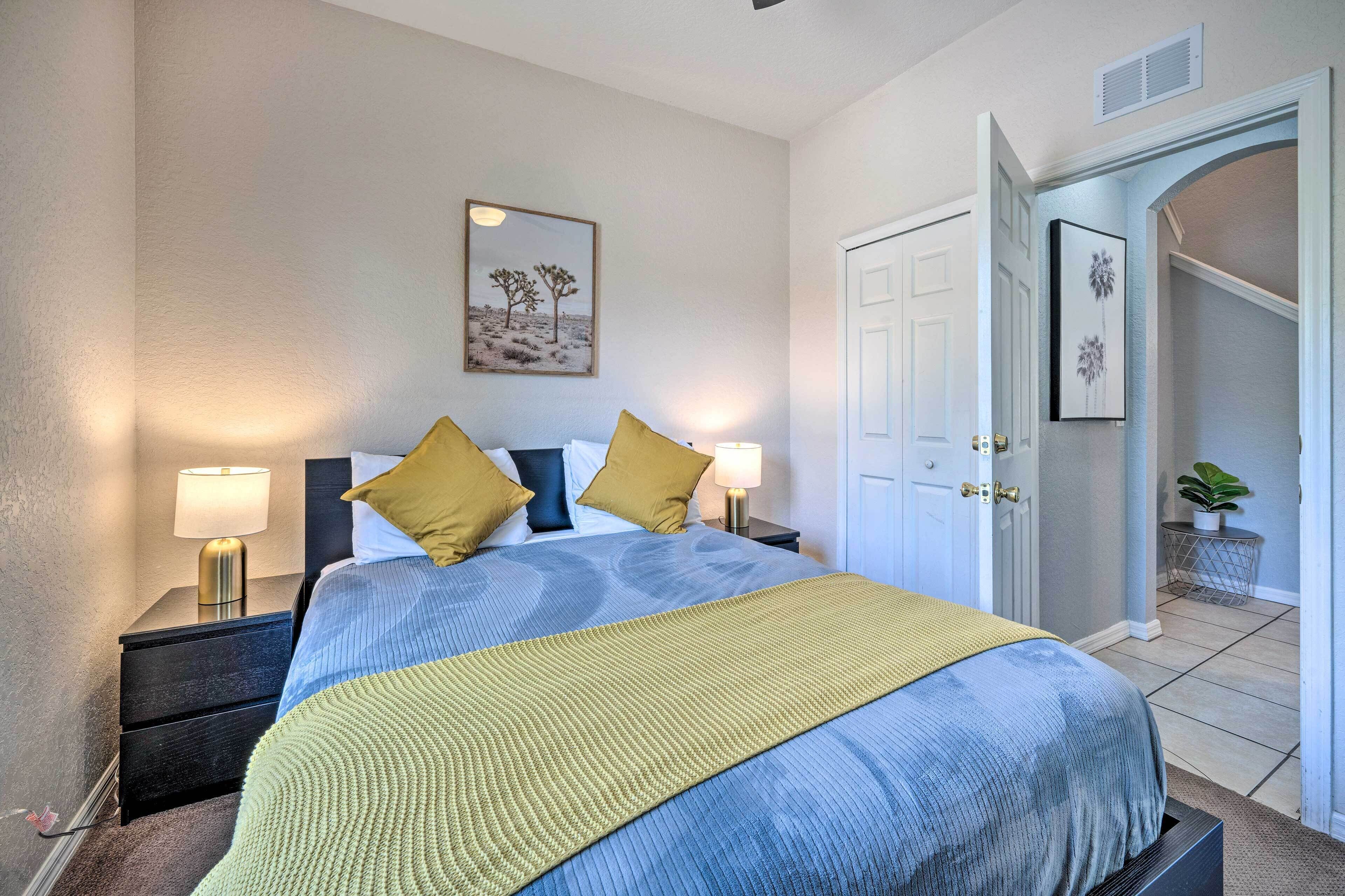 A bedroom with a bed, nightstands, a lamp, and a door.