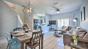 A modern kitchen with a dining area, a living room with a sofa, and a staircase. - Chic Resort Townhome ~ 9 Mi to Disney Parks! (Davenport)