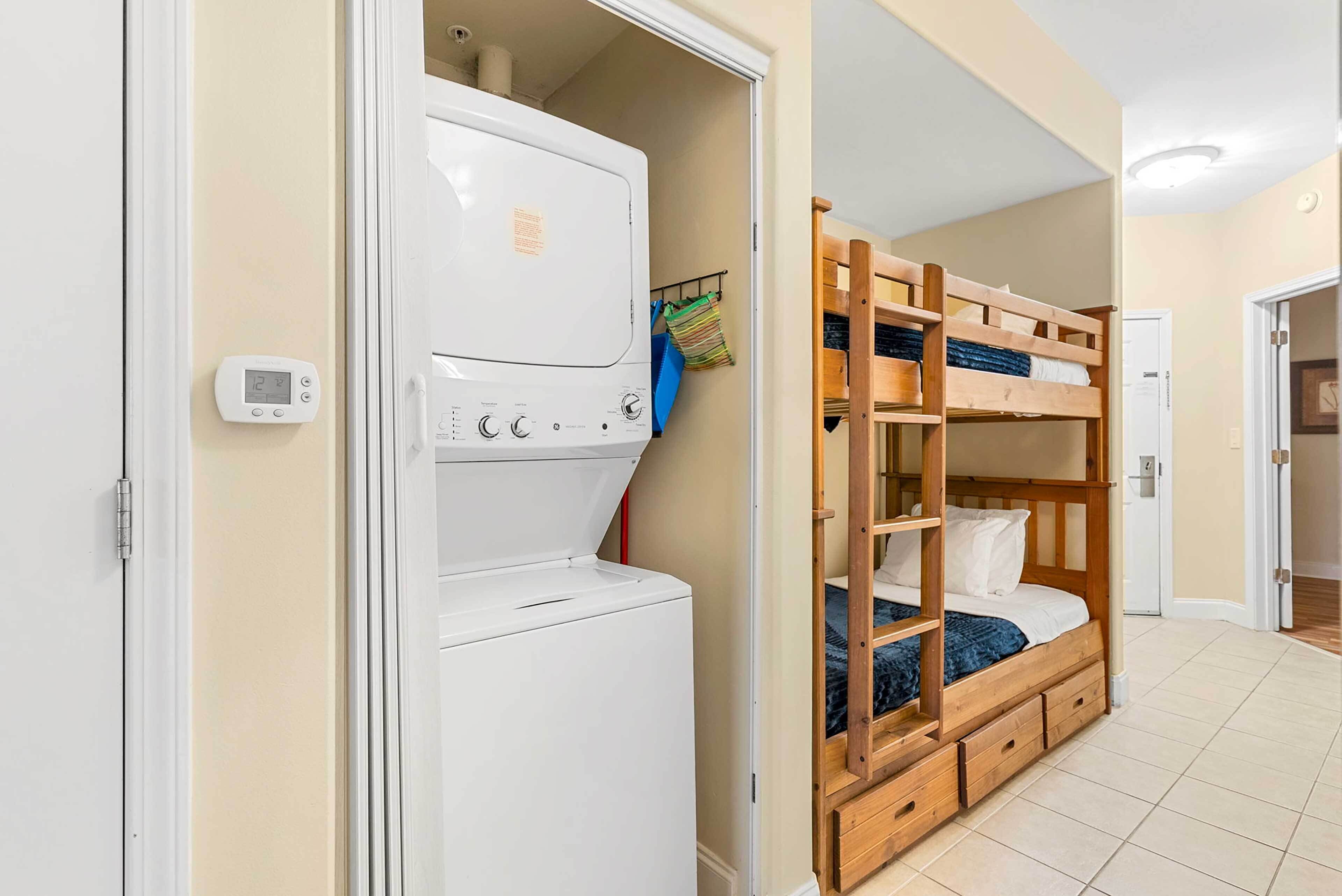 A compact room with a bunk bed, a washing machine, and a small closet.