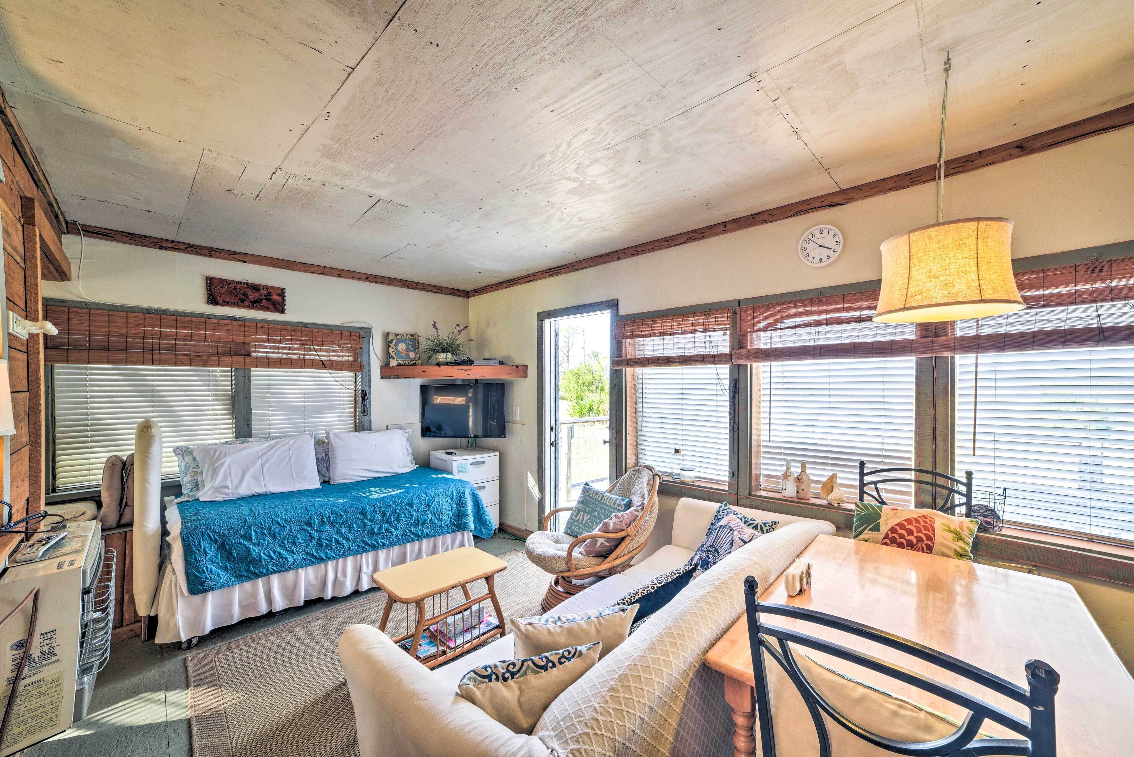 Una habitación acogedora con una cama, un sofá, una mesa y un televisor.
