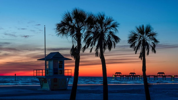 A lifeguard tower and palm trees on a beach at sunset. - Coastal 'sea Side' Townhome - Walk to Beach! (Clearwater Beach)