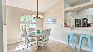 A kitchen with a dining area, a chandelier, and a view to the outside. - Colorful Cape Coral Vacation Rental w/ Pool! (Cape Coral)