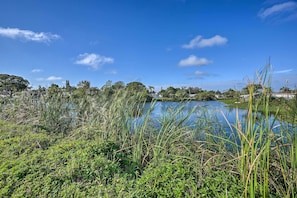 A serene lakeside view with lush greenery and a clear blue sky. - Cozy Holiday Home w/ Yard ~ 5 Mi to Beach! (Holiday)